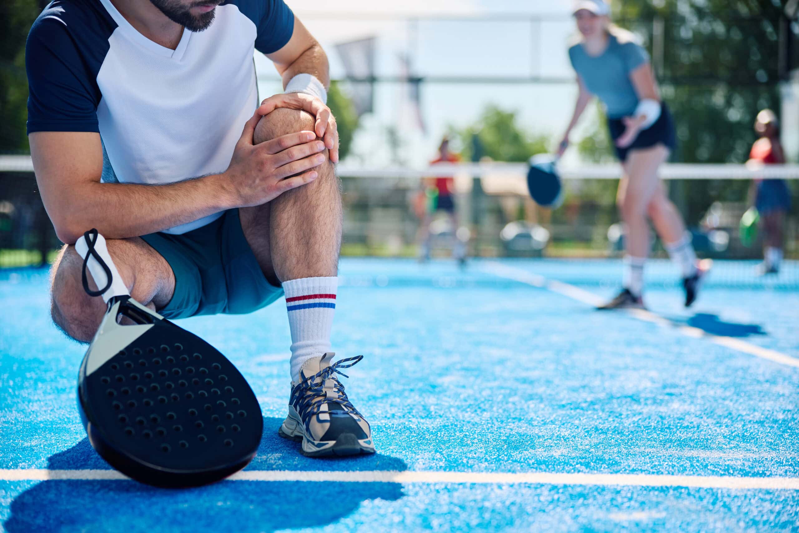Close up of athlete feeling pain in his knee while playing padel on outdoor tennis court. El pàdel enganxa. És social, s'aprèn ràpid i permet competir des del primer dia, una cosa que pocs esports aconsegueixen. Precisament per això, moltes persones passen de jugar un dia solt a jugar dos o tres cops per setmana en qüestió de mesos, sense que el cos hagi tingut temps d'adaptar-se a aquesta nova càrrega. I és aquí on apareixen les molèsties: el colze que punxa en obrir una porta, l'espatlla que avisa a la safata, el turmell que es torça en un canvi de direcció. Parlar de lesions, pàdel i prevenció no va de deixar de jugar ni d'espantar ningú. Va d'entendre què li demana aquest esport al teu cos i què pots fer per seguir a la pista molts anys. En aquest article repassem les lesions més habituals, per què passen i quines mesures realistes funcionen per reduir-ne el risc.